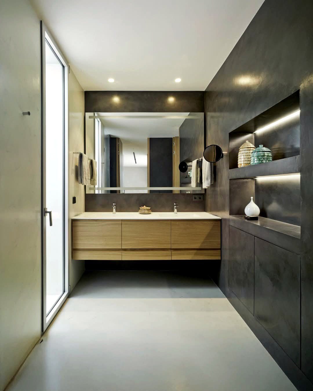 Bathroom vanity wall and floor finished in dark microcement with a wall-hung unit
